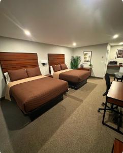 una camera con 2 letti e una scrivania di Manitoulin Inn a Mindemoya