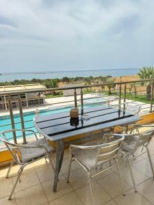 a table and chairs on a balcony with a pool at Pachia Ammos Falasarna in Falasarna