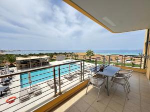 a balcony with a table and chairs and the ocean at Pachia Ammos Falasarna in Falasarna