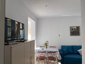 a living room with a table and a blue couch at Top Floor Apartment in Velipojë