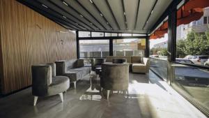 a waiting room with chairs and tables and windows at Nativo Otel in Antalya