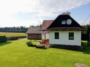 a small white house with a black roof at Chalupa SVRATKA in Moravská Svratka