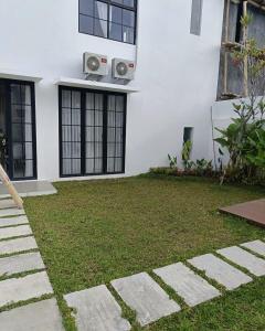 a house with a lawn in front of it at JessAble Home Stay in Manado