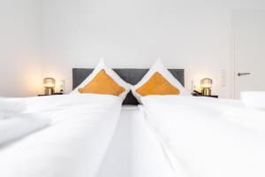 two beds in a bedroom with orange pillows at Golden Timber Suite in Rittersdorf