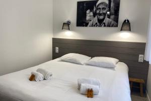 a bedroom with a white bed with towels on it at Villa Thaïlande - Domaine Le Sherwood in Notre-Dame-de-Monts