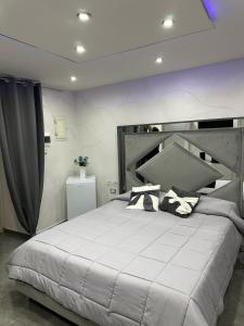 een slaapkamer met een groot wit bed met kussens bij Patty House in Napels +16 foto's