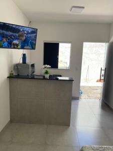 a room with a counter with a tv on the wall at Kit 5 km do aeroporto in Brasilia