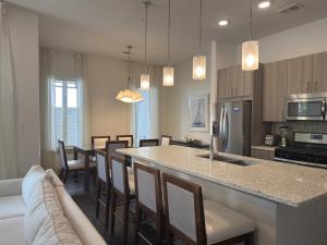 a kitchen and dining room with a counter and chairs at The Pointe Unit 111 by 30A Escapes in Rosemary Beach