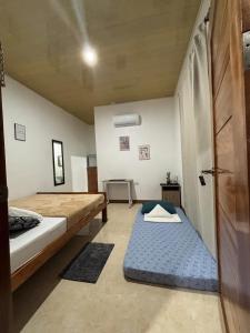 a room with two beds and a door with a mattress at Felomina Guesthouse in San Juan