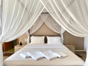 a bedroom with a canopy bed with two white towels at Pachia Ammos Falasarna in Falasarna
