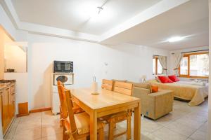 a kitchen and living room with a table and a couch at Depto Del lago, con la mejor vista y cercano a todo - Ayres del Bosque Alojamientos in San Martín de los Andes
