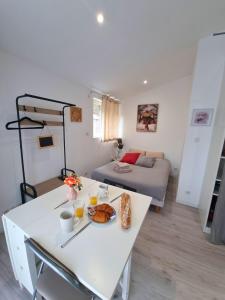 a living room with a table and a bed at Le Petit Brevin in Saint-Brevin-les-Pins