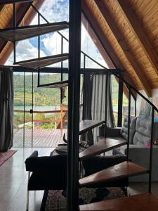 een woonkamer met een groot raam en houten plafonds bij Bangallo Dona Maria in Nonoai