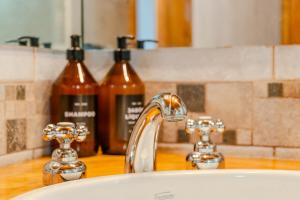 a bathroom sink with two bottles of soap at Depto Del lago, con la mejor vista y cercano a todo - Ayres del Bosque Alojamientos in San Martín de los Andes +26 photos