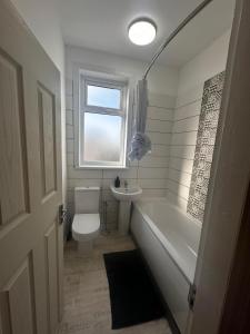a bathroom with a toilet and a tub and a sink at Lovely home in Manchester in Manchester