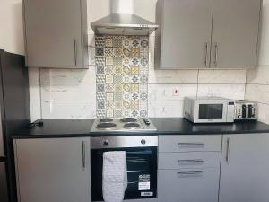 a kitchen with a stove and a microwave at Lovely home in Manchester in Manchester +6 photos