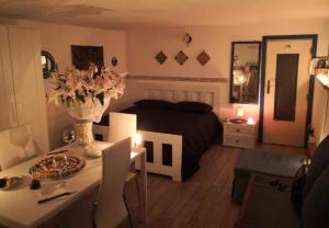 a bedroom with a bed and a table with a vase of flowers at Mondello Room in Mondello