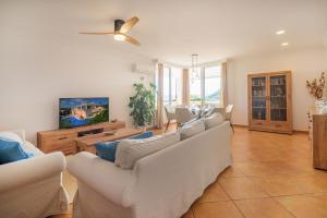 a living room with couches and a flat screen tv at Villa Rafael muy tranquilo y piscina privada in Punta Prima