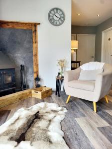 a living room with a chair and a fireplace at Woodland View Retreat - Luxury Stay, Endless Fun in Upton Warren