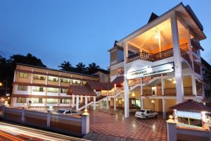 a building with two cars parked in front of it at Rajavalsam Guruvayur in Guruvāyūr