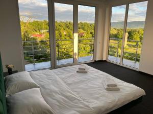 a white bed in a room with a large window at ALLIANCE Hotel NEW 2025 -Breakfast and pool included in Solotvyno