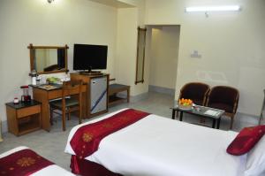 a hotel room with a bed and a flat screen tv at Quality Inn Dhaka in Dhaka