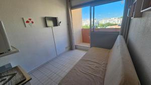 a room with a bed and a large window at Studio - 2min Mer & Plages - Grau du Roi in Le Grau-du-Roi