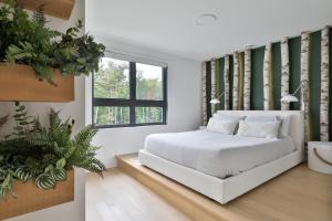 a bedroom with a white bed and a window at Verbier by Tremblant Platinum in Mont-Tremblant
