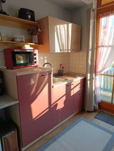 a kitchen with pink cabinets and a sink and a microwave at Ferienland Sonnenwald Studio 50 in Schöfweg