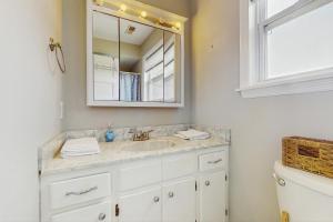a bathroom with a sink and a mirror at Carolina Sunshine Waterfront in North Topsail Beach +20 photos