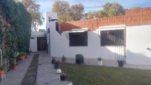 a white house with a courtyard with potted plants at Gustavo in Villa Mercedes