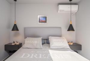 a bedroom with a bed with two pillows on it at Argostoli Haven - Luxury House in Argostoli