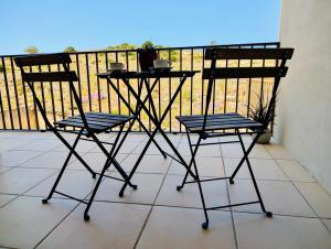 two chairs and a table on a balcony at Sunset Haven Manikata - Walking distance to Golden Bay in Manikata