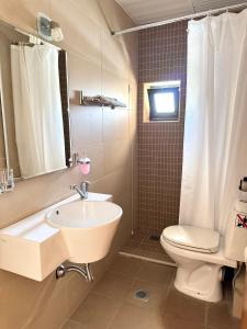 a bathroom with a sink and a toilet and a mirror at Pachia Ammos Falasarna in Falasarna
