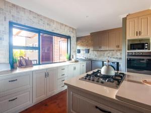 a kitchen with white cabinets and a stove and a window at CK House in Wilderness