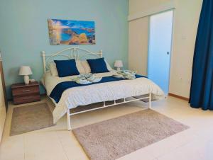 a bedroom with a bed with blue walls and blue curtains at Sunset Haven Manikata - Walking distance to Golden Bay in Manikata
