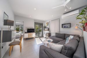 a living room with a couch and a tv at Argostoli Haven - Luxury House in Argostoli