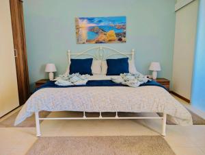 a bedroom with a large bed with blue walls at Sunset Haven Manikata - Walking distance to Golden Bay in Manikata