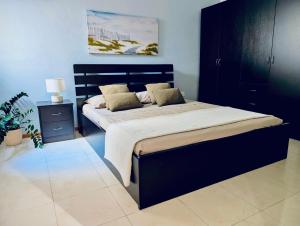 a bedroom with a large bed with a black headboard at Sunset Haven Manikata - Walking distance to Golden Bay in Manikata