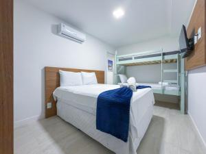 a bedroom with a large bed and a tv at Apartamento Vista Mar a 50m da Praia dos Anjos com Piscina, Churrasqueira Privativa e Estrutura de Lazer Completa in Arraial do Cabo