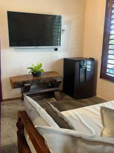 a living room with a tv and a couch and a table at KiteHouseArpoeiras in Acaraú