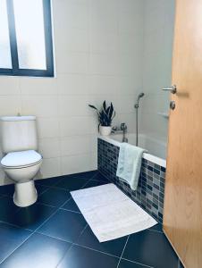 a bathroom with a toilet and a sink and a shower at Sunset Haven Manikata - Walking distance to Golden Bay in Manikata