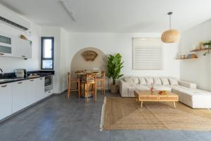 a living room with a white couch and a table at טל תאי בוטיק - Tal Thai Boutique in Shelomi +30 photos