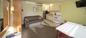 eine Küche und ein Wohnzimmer mit Sofa und Tisch in der Unterkunft Waterfront Inn in Penticton