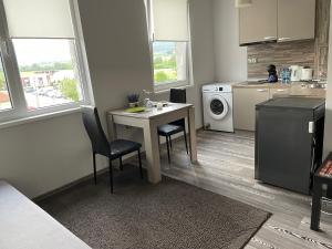 a kitchen with a table and two chairs and a sink at Апартамент Димана in Hisarya