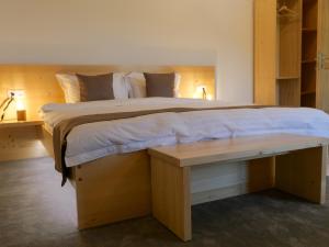 a bedroom with a large bed and a wooden bench at ZAMURA Casa in Bozioru