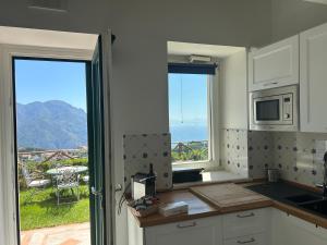 una cucina con finestra e vista sull'oceano di The little tower of Minuta a Scala