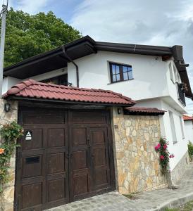 una casa con un garage con una porta da garage marrone di Newly Built Family Villa with a Jacuzzi a Sopot