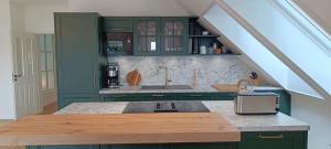 una cucina con mobili verdi e un piano di lavoro di Ferienwohnung Coproyshof am See in Wesel am Niederrhein 5 Sterne DTV-Klassifizierung 6 Personen a Wesel