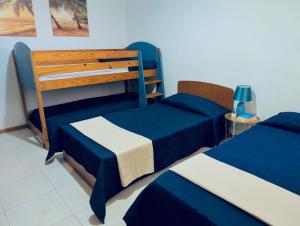 two beds in a room with blue and white at Sunset Haven Manikata - Walking distance to Golden Bay in Manikata